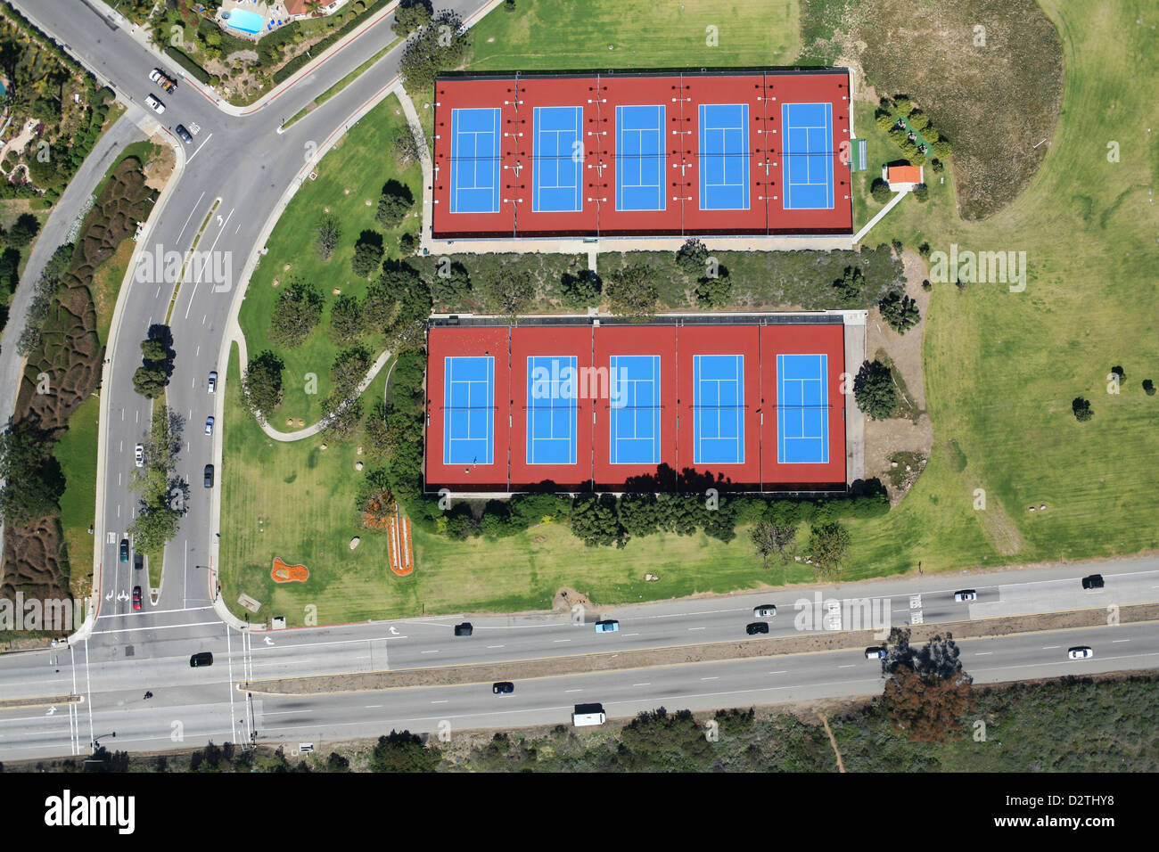 VERTICAL AERIAL VIEW. Tennis courts alongside Pacific Coast Highway 1. Malibu, Los Angeles County, California, USA. Stock Photo
