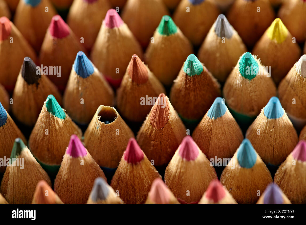 Grid of coloured wooden artist pencils with an odd one out Stock Photo