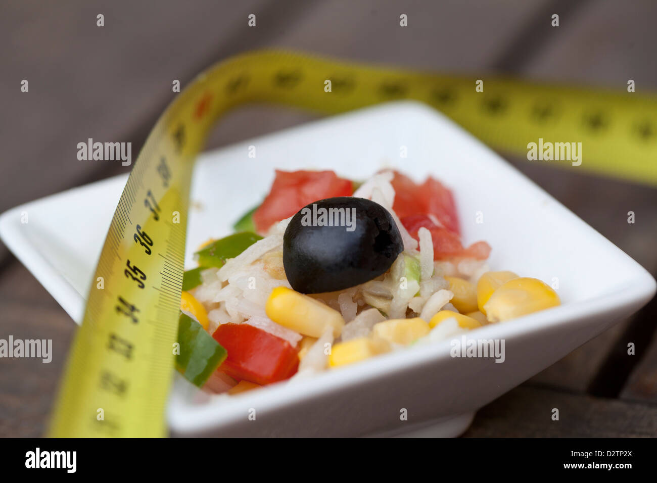 Healthy summer rice salad with tomato, onions, corn, peppers, black olives and avocado good for your diet. Stock Photo