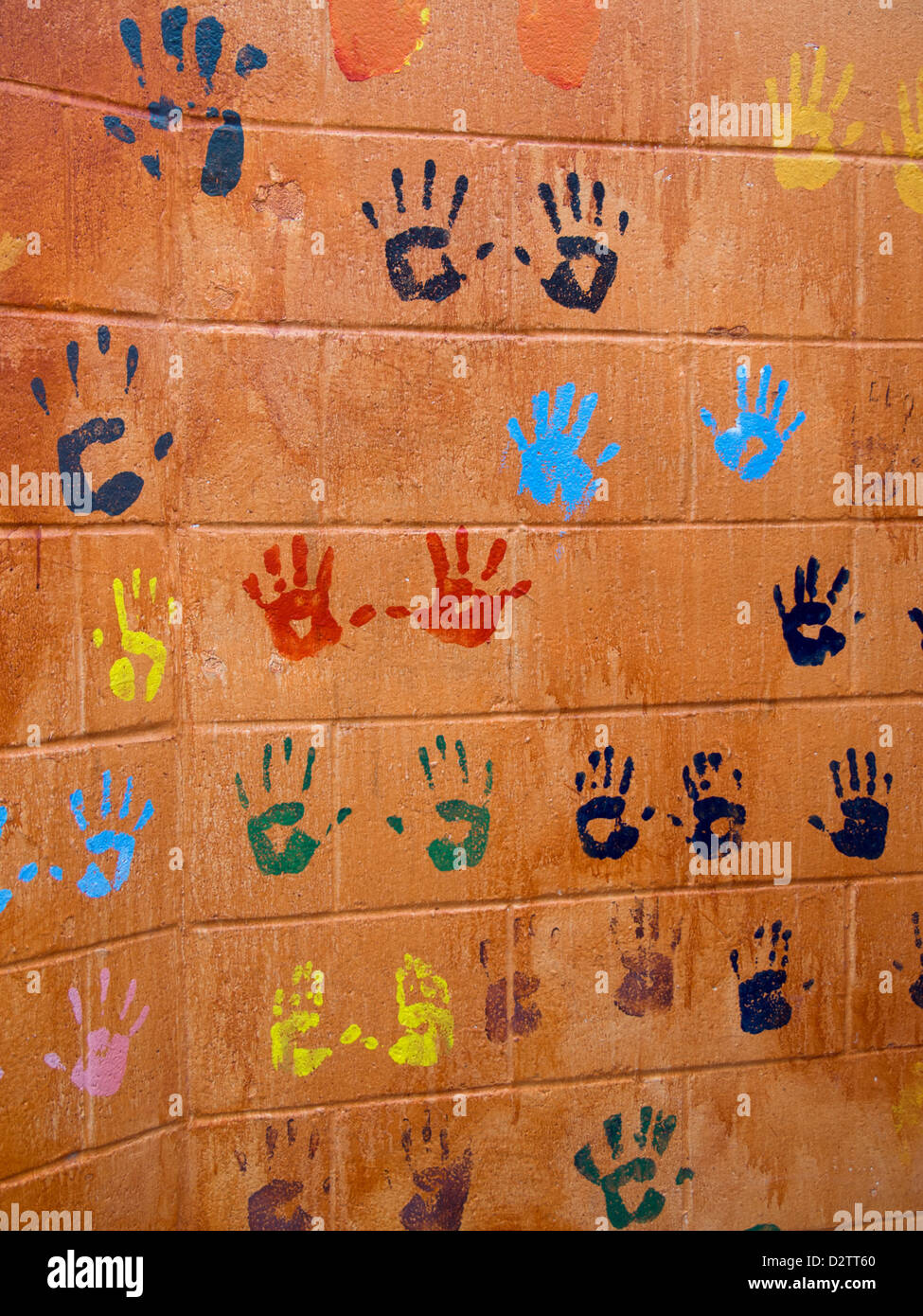 Colorful childrens' handprints on an orange wall in Austin, Texas Stock Photo