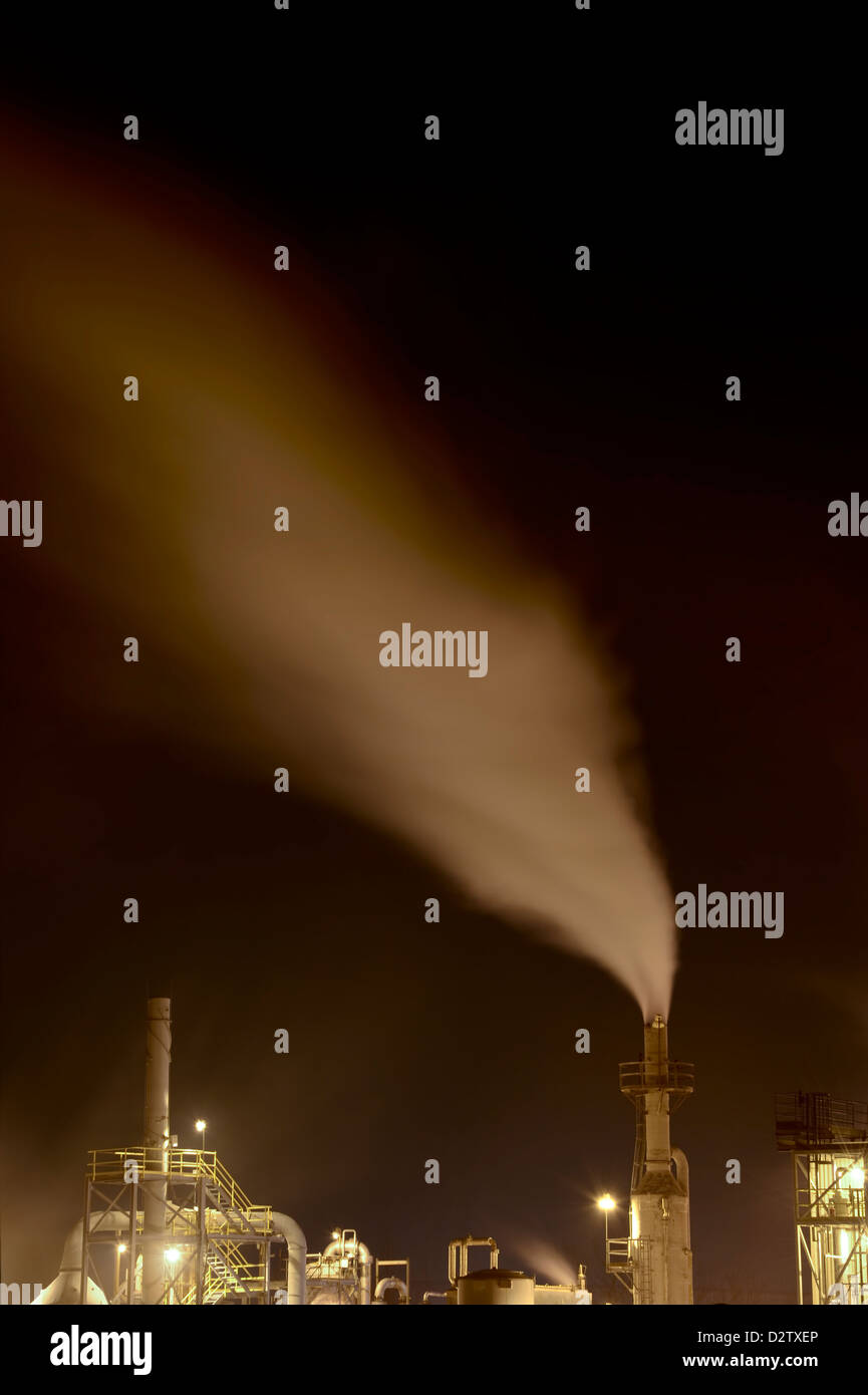 Smoke Stacks At Night With Blurry Emissions Stock Photo