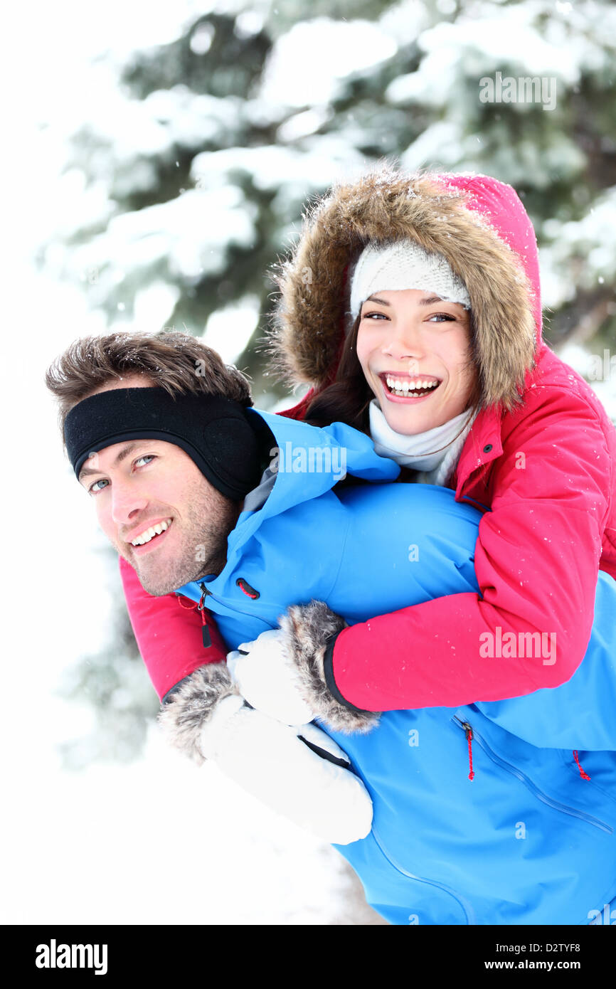 Happy and excited beautiful young multiracial couple enjoying piggyback ...