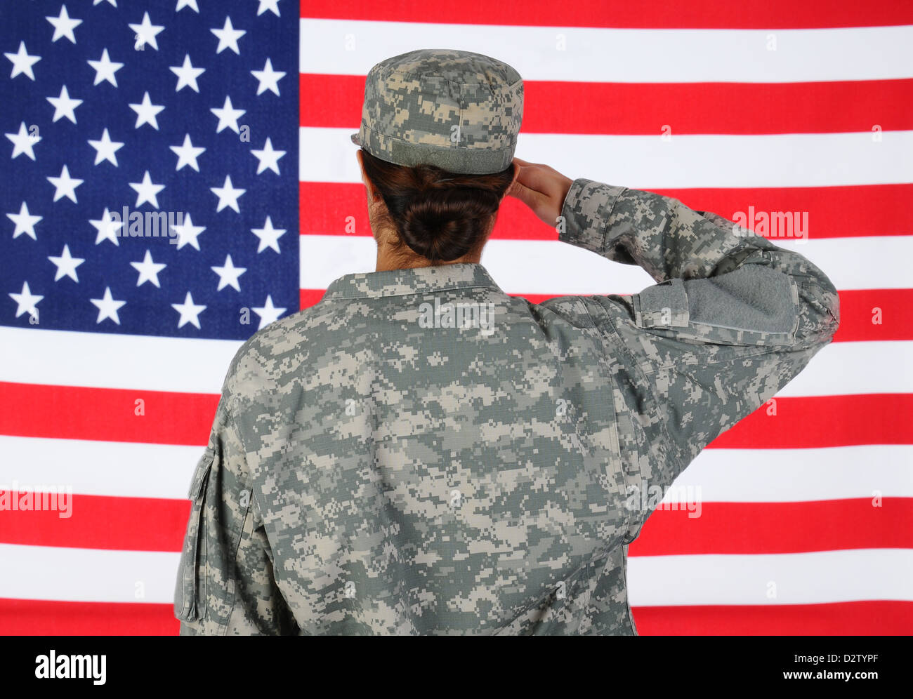 Closeup of an American Female Soldier in combat uniform saluting a flag. Stock Photo