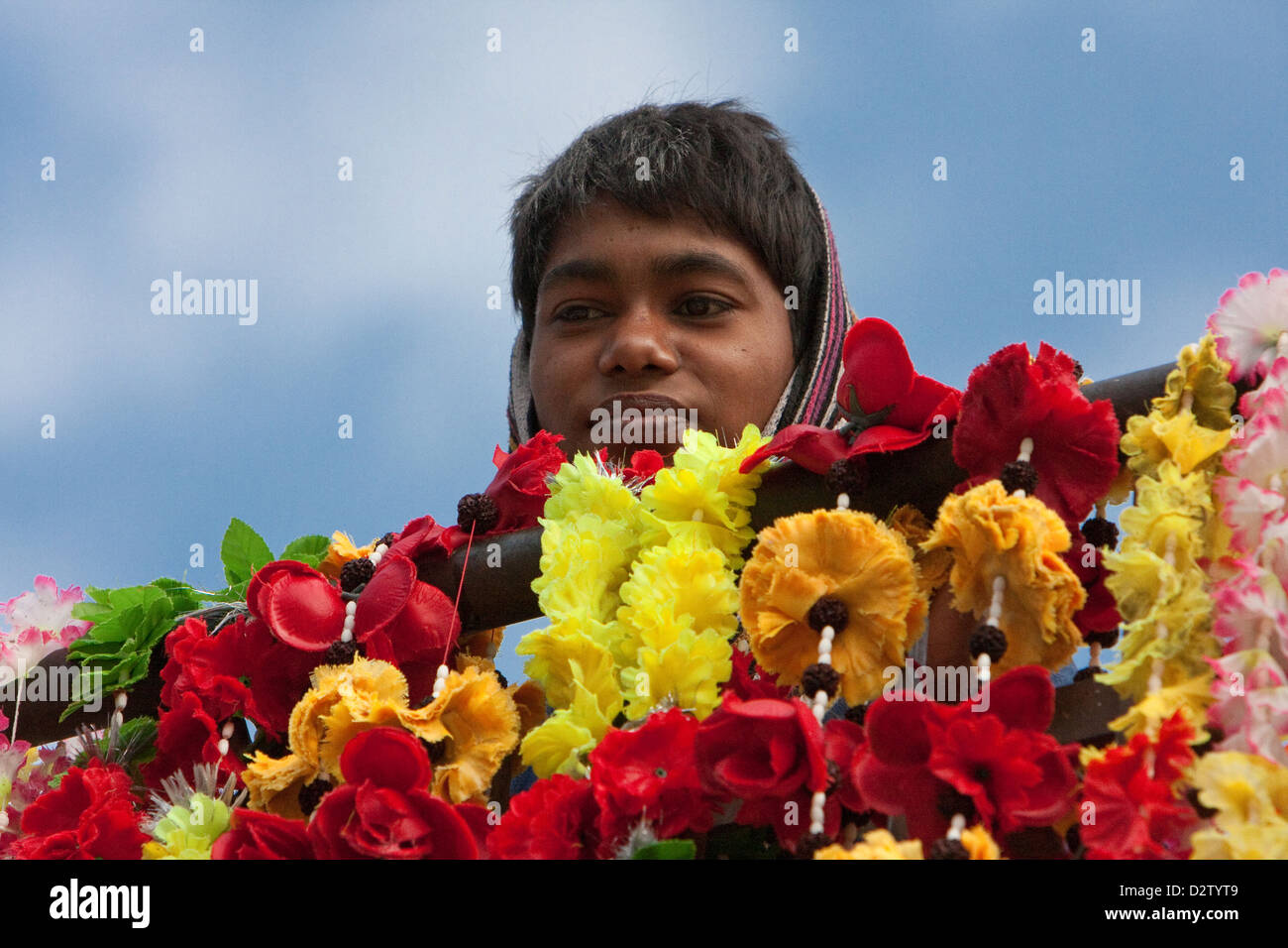 India, Rishikesh. Boy with Flowers for Sale as Offerings. Stock Photo