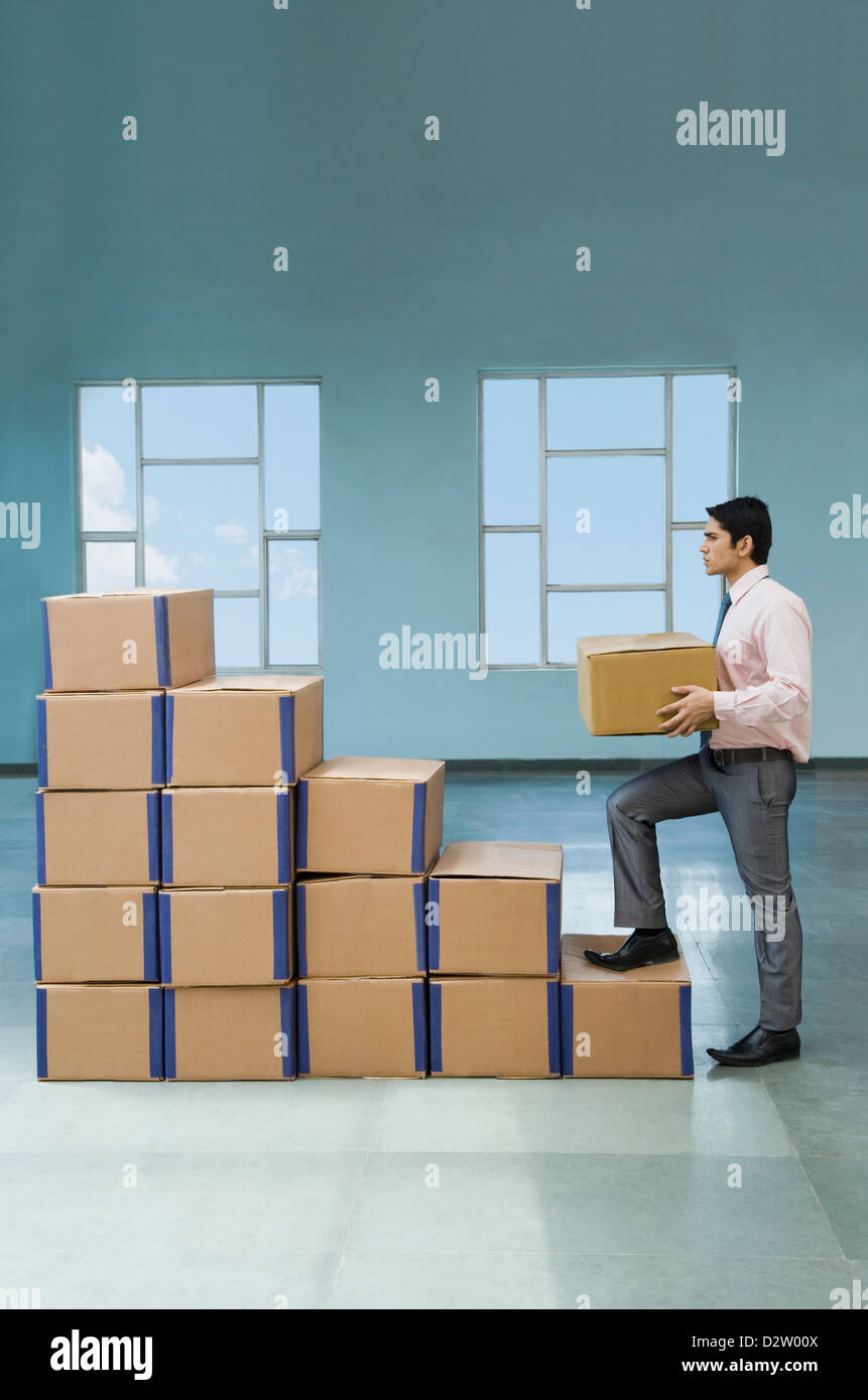 Businessman stacking cardboard boxes in shape of rising bar graph Stock ...