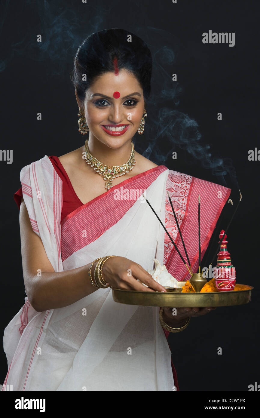 Indian woman in traditional clothing holding religious offering Stock