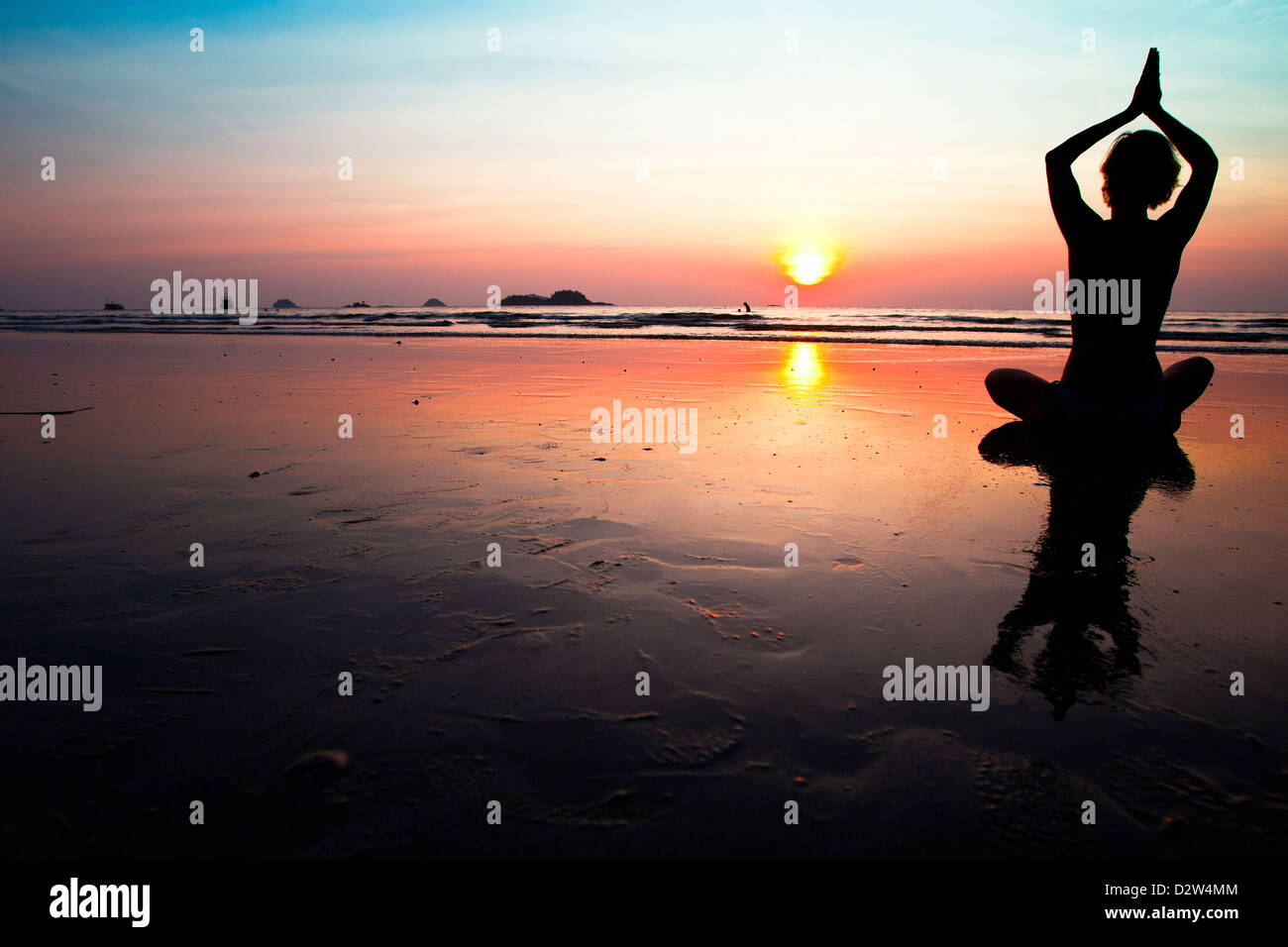 Silhouette of a woman meditating on the beach at sunset Stock Photo - Alamy