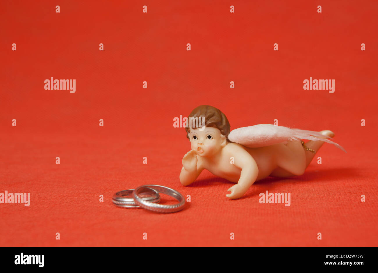 Two silver rings with angel in red background Stock Photo - Alamy