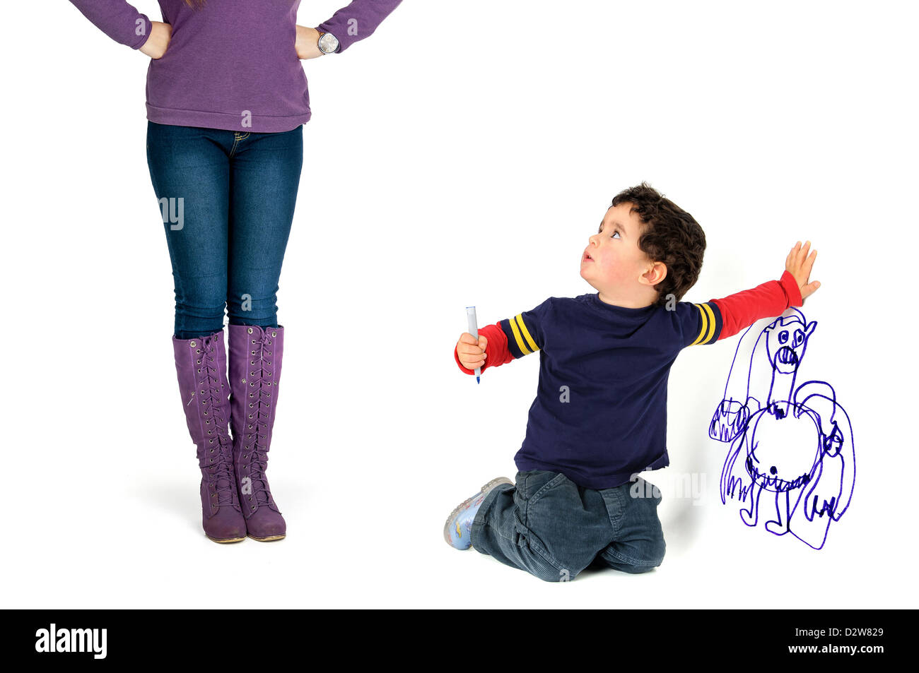 Young boy caught by his mother painting the wall Stock Photo