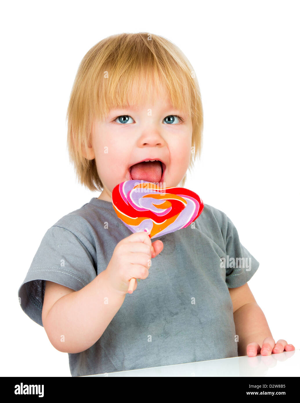 Baby eating a sticky lollipop on white background Stock Photo