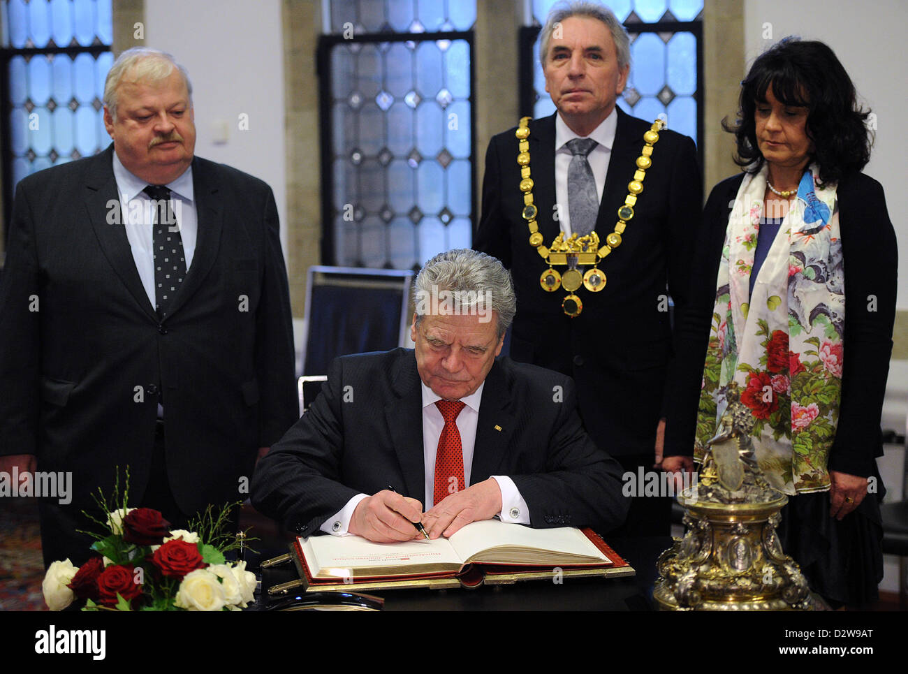 German President Joachim Gauck signs the Golden Book of Cologne at the historic city hall in Cologne, Germany, 02 February 2013. Nort Rhine-Westphalian Minister of Labour, Integration and Social Affairs, Guntram Schneider (SPD, L), mayor of Cologne Juergen Roters (SPD, 2-R) and his wife Angela look on. Gauck also visited the Kolping Society on the occasion of the 200th birthday of its founder Adolph Kolping. Photo: Henning Kaiser Stock Photo