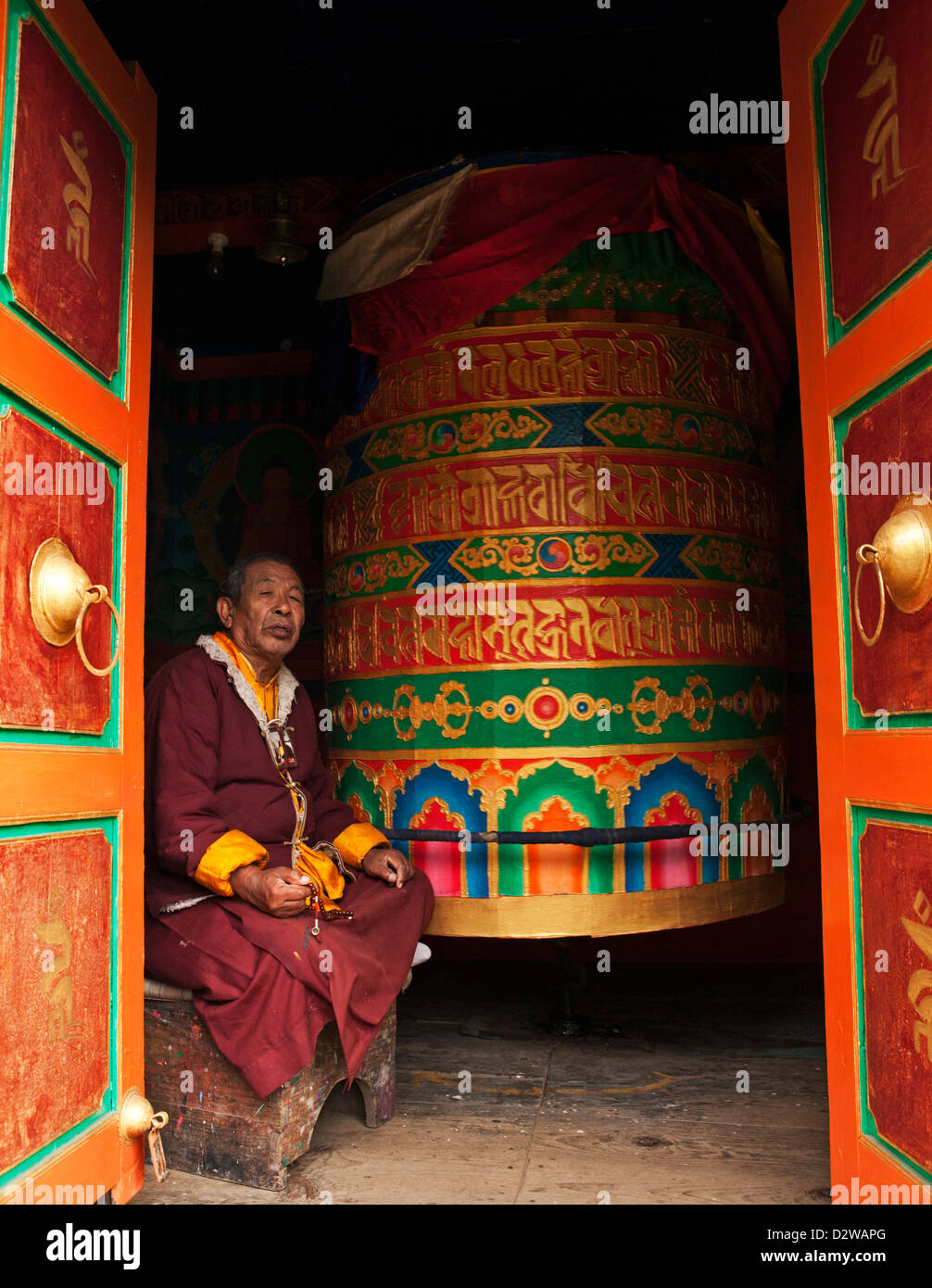 Monk praying in a prayer wheel house along the everest trek in Nepal. Stock Photo