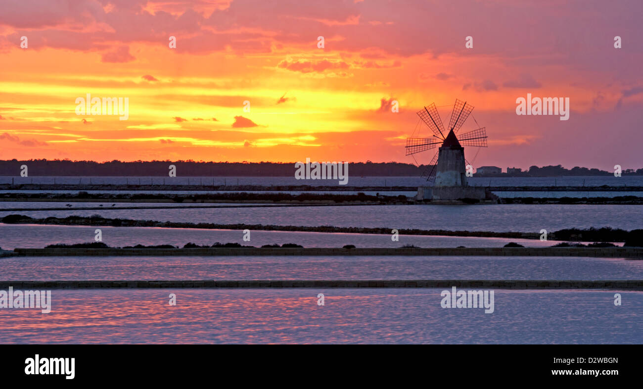 Windmill at Infersa Salt Pans at sunset in Marsala, Sicily, Italy. Stock Photo