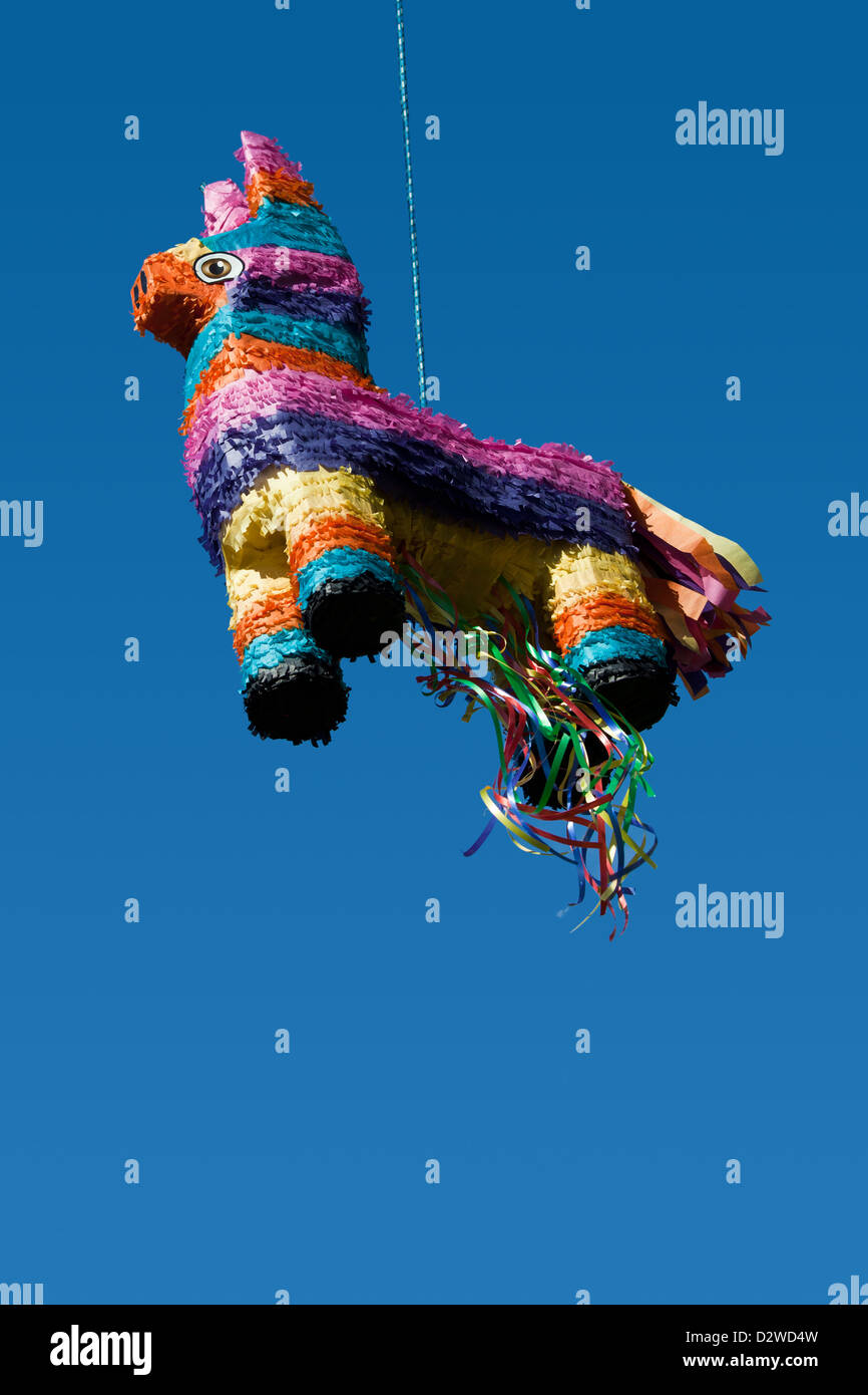 A colorful and festive pinata hangs from a rope ready to burst