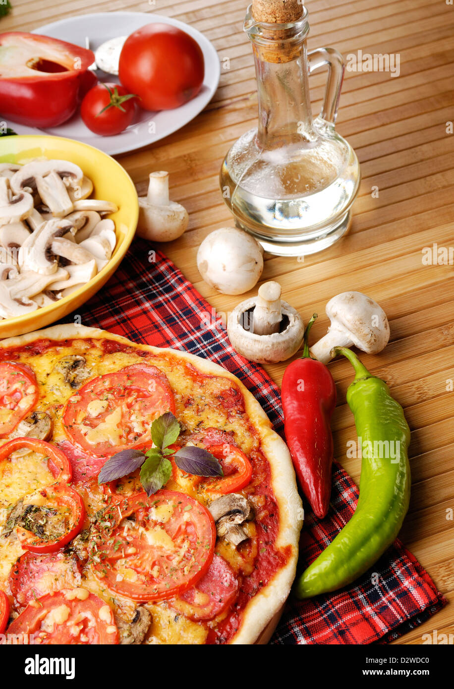 Pizza with mushrooms on the wooden table with vegetables Stock Photo