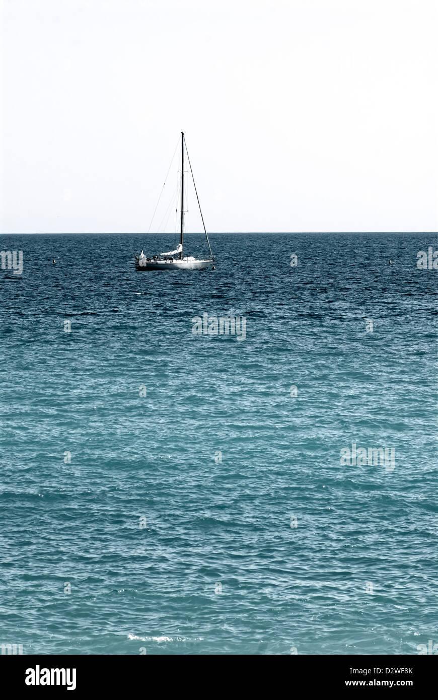 Sailboat setting into the horizon. Stock Photo