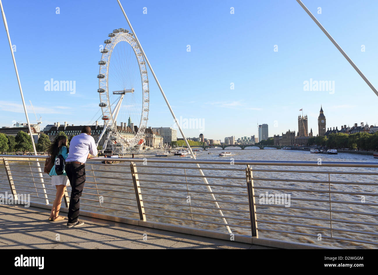Couple looking at the view west from the Golden Jubilee Bridge over the river Thames, on a summer's evening, in London, UK Stock Photo