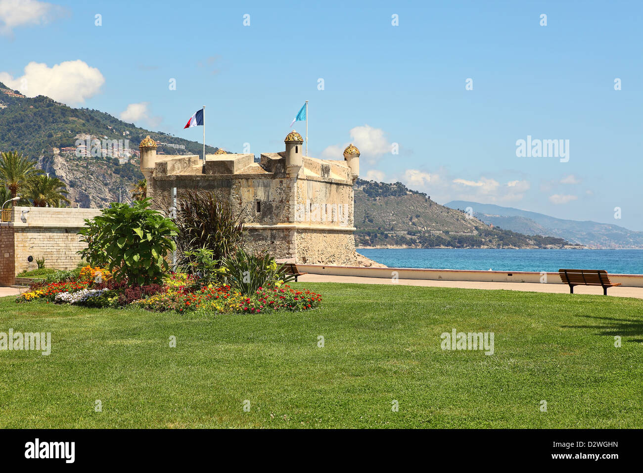 Small garden with green grass and old bastion on the shore of Mediterranean sea in town of Menton on French riviera in France. Stock Photo