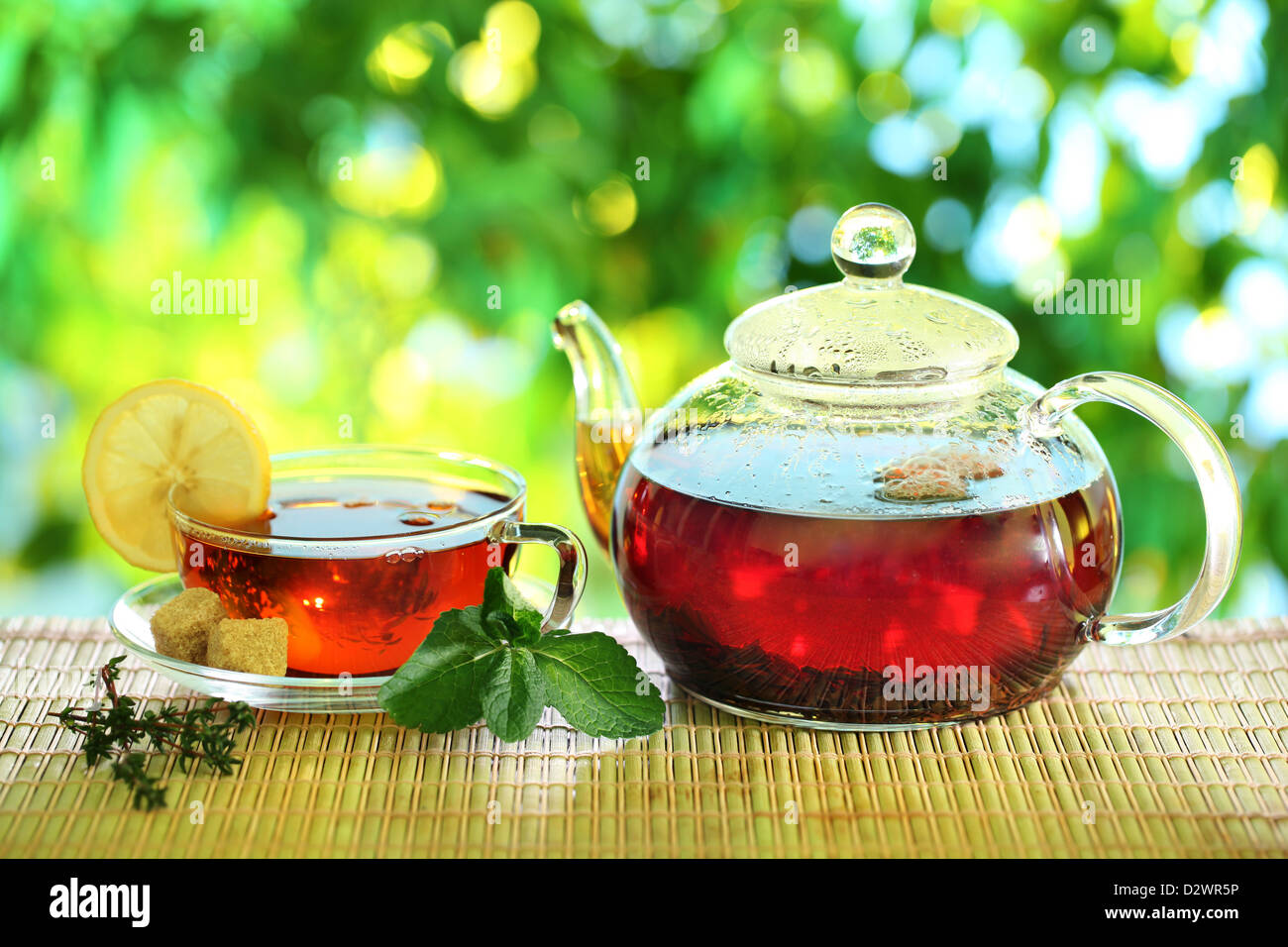 Cup of tea and teapot on a blurred background of nature. Stock Photo