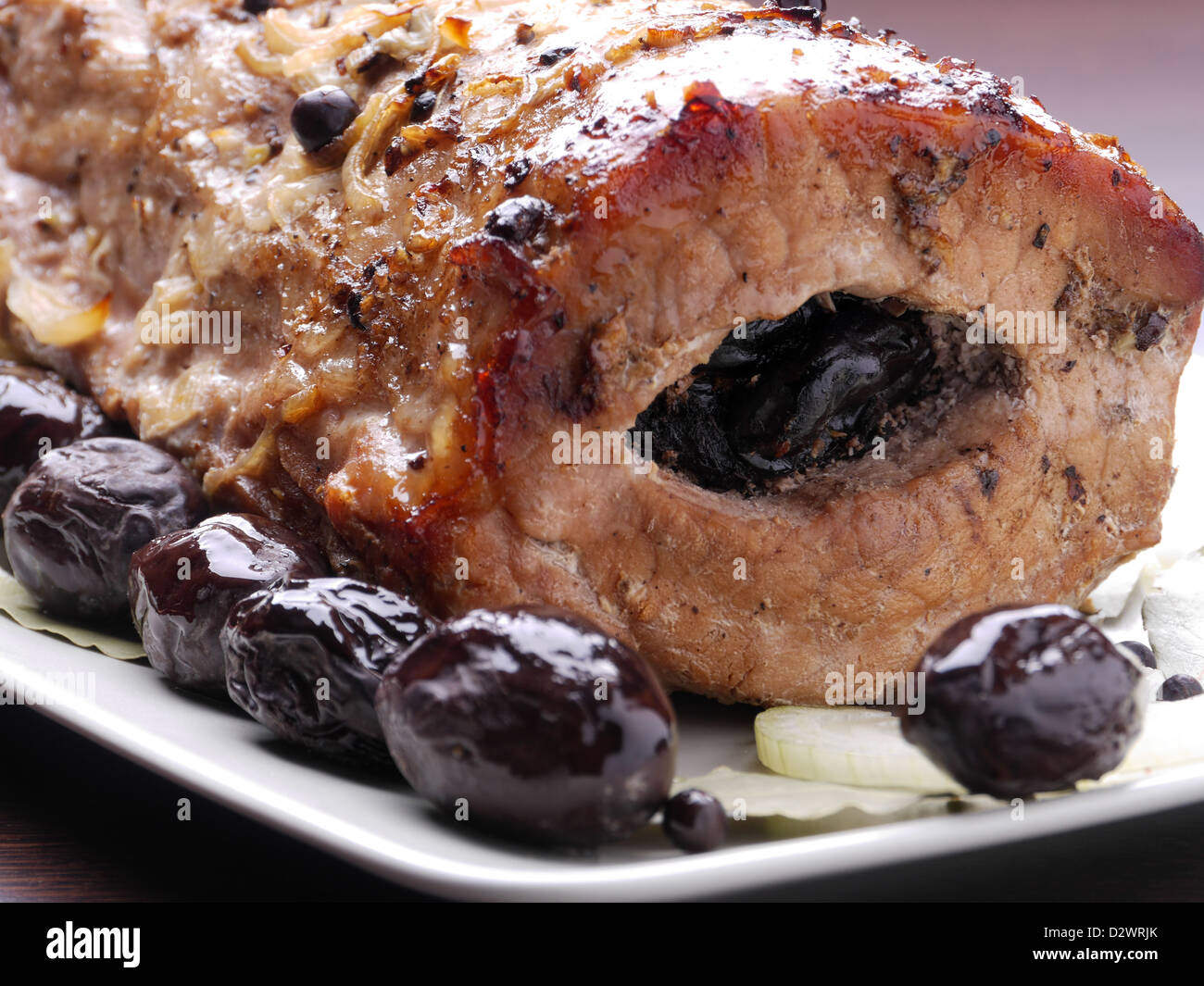 Plum staffed roasted pork loin served on plate Stock Photo