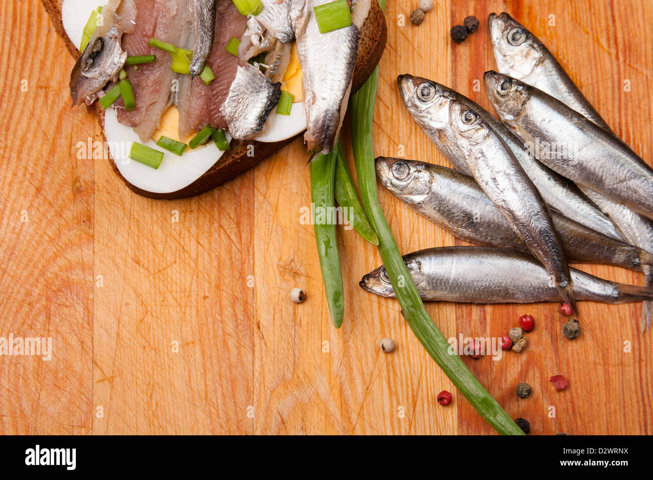 sandwich from salted anchovies with egg and spring onion on wood Stock