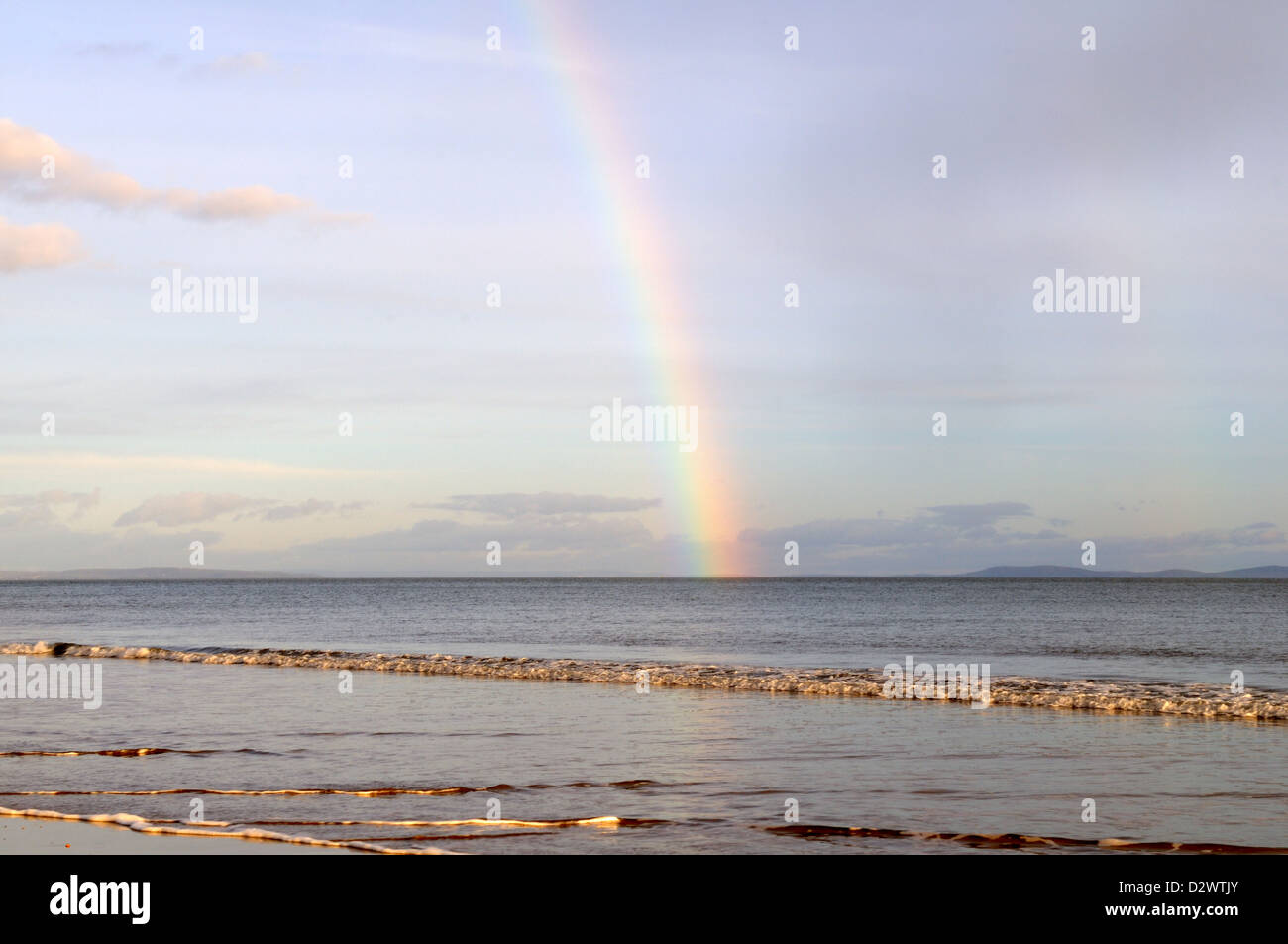 Rainbow over the sea at sunset Tenby South Beach Pembrokeshire Wales Cymru UK GB Stock Photo