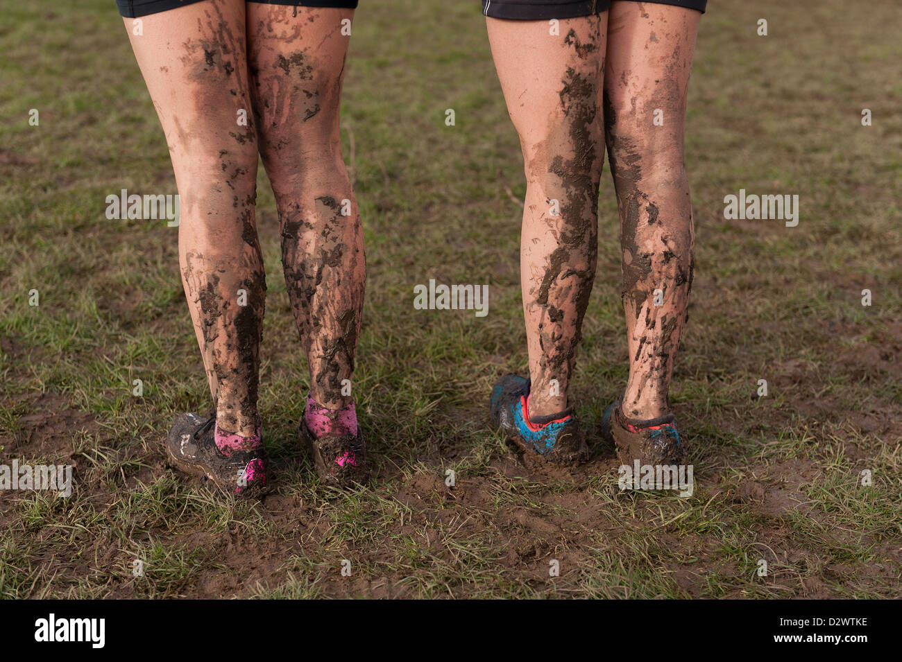 Cross Country Championships senior and inter youth girls extremely muddy conditions splattered mud on back of legs standing Stock Photo