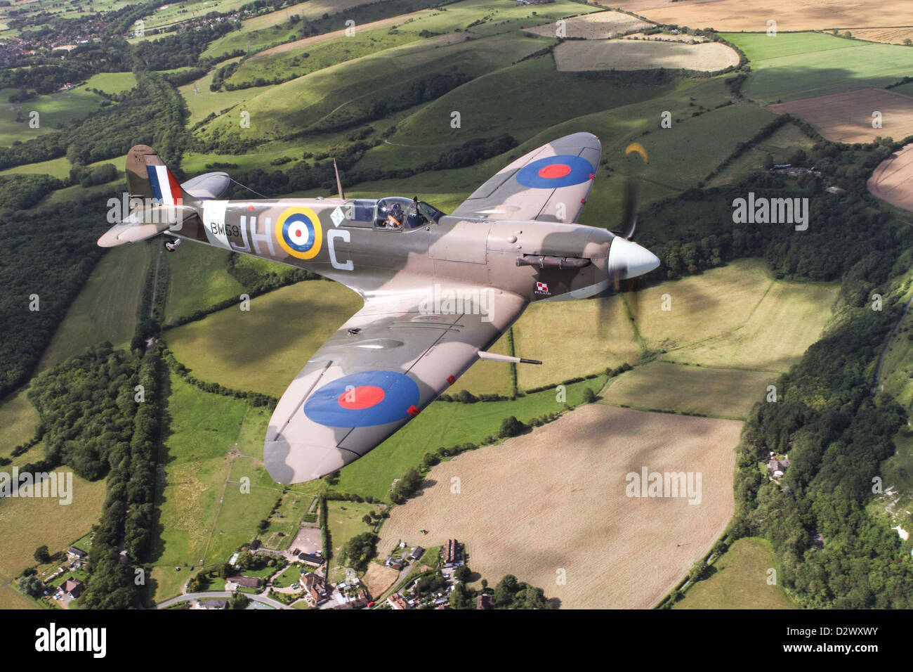 An aerial view of a Spitfire flying over Kent countryside Stock Photo