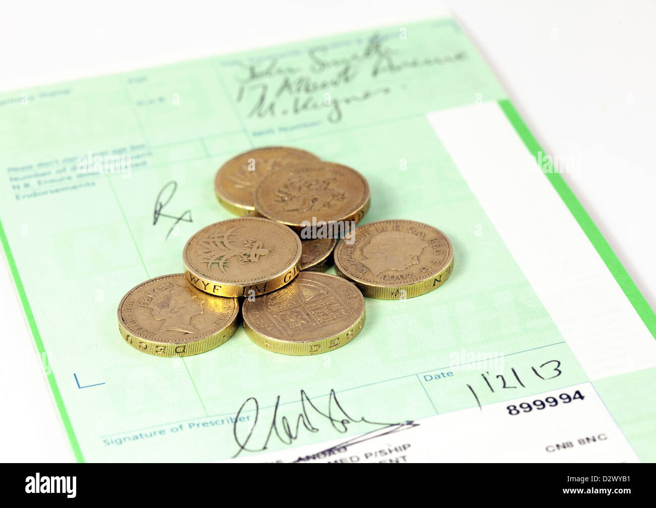 Pound coins on a prescription pad - concept image of prescription charges in the NHS, UK Stock Photo