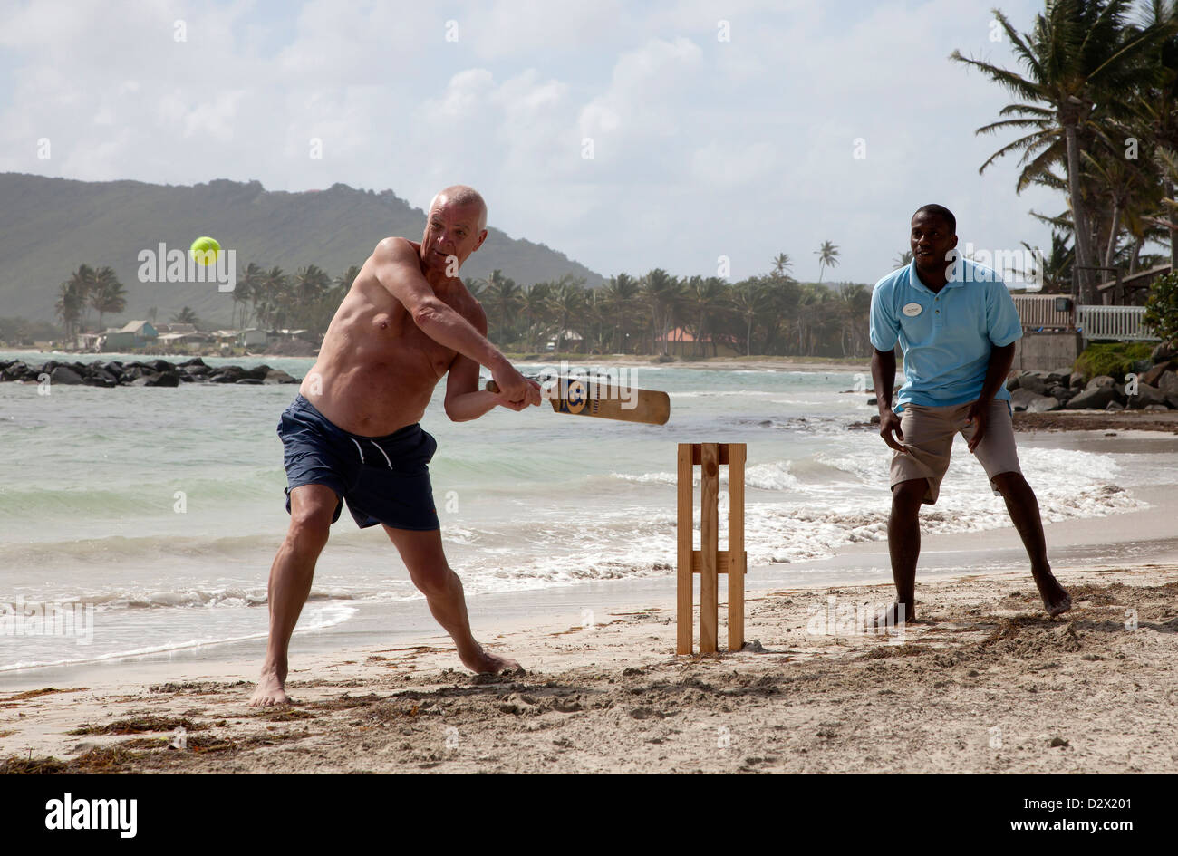 Tourist playing beach cricket, St Lucia, Stock Photo