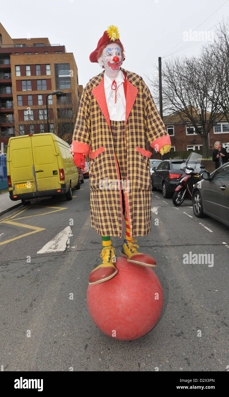 dalston-london-uk-3rd-february-2013-a-clown-balancing-on-a-ball-outside-D2X3PN.jpg