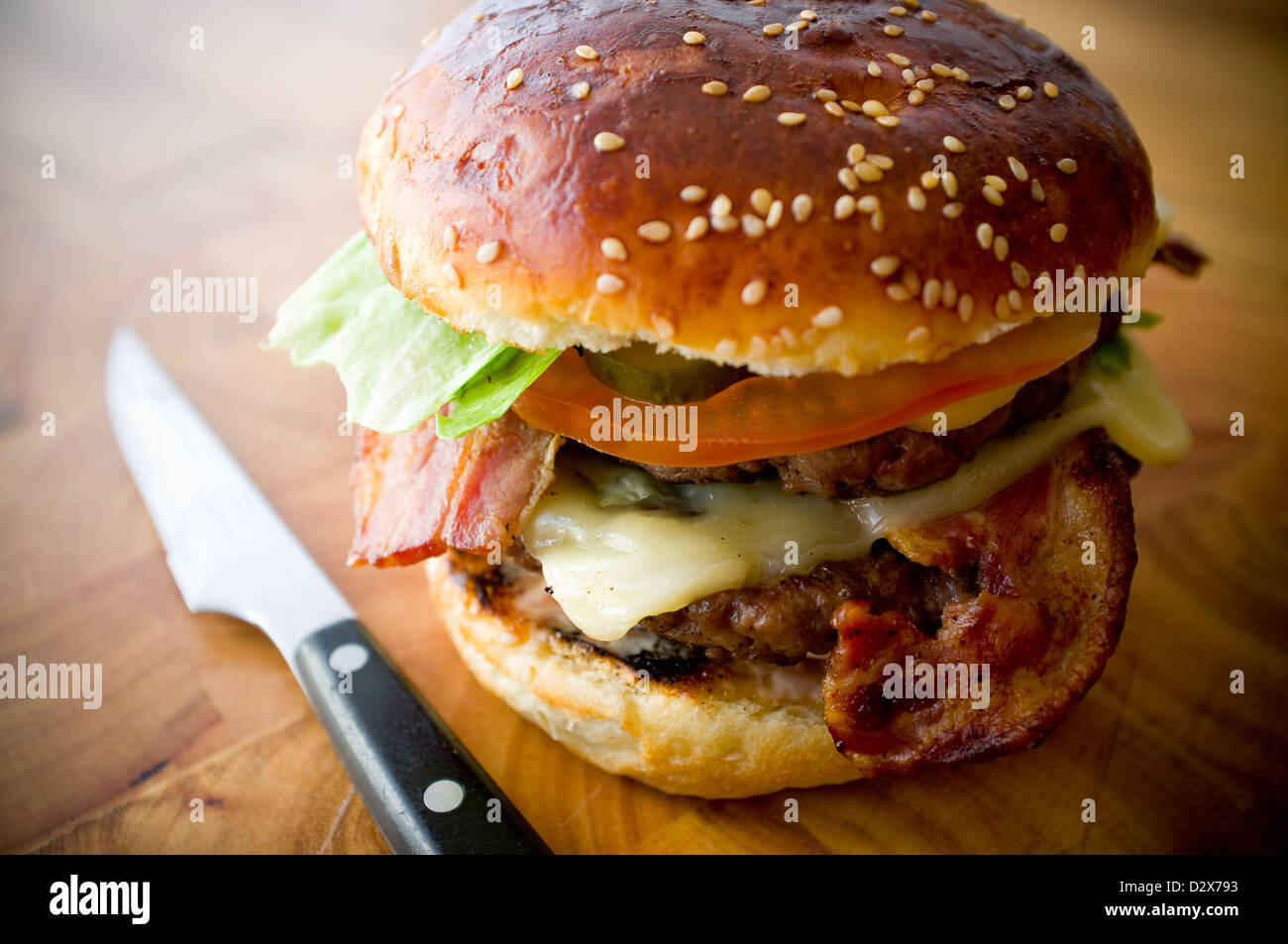 Double Cheese - Two burgers, layered with cheese, bacon, tomato, lettuce, pickle, onion, and burger sauce Stock Photo