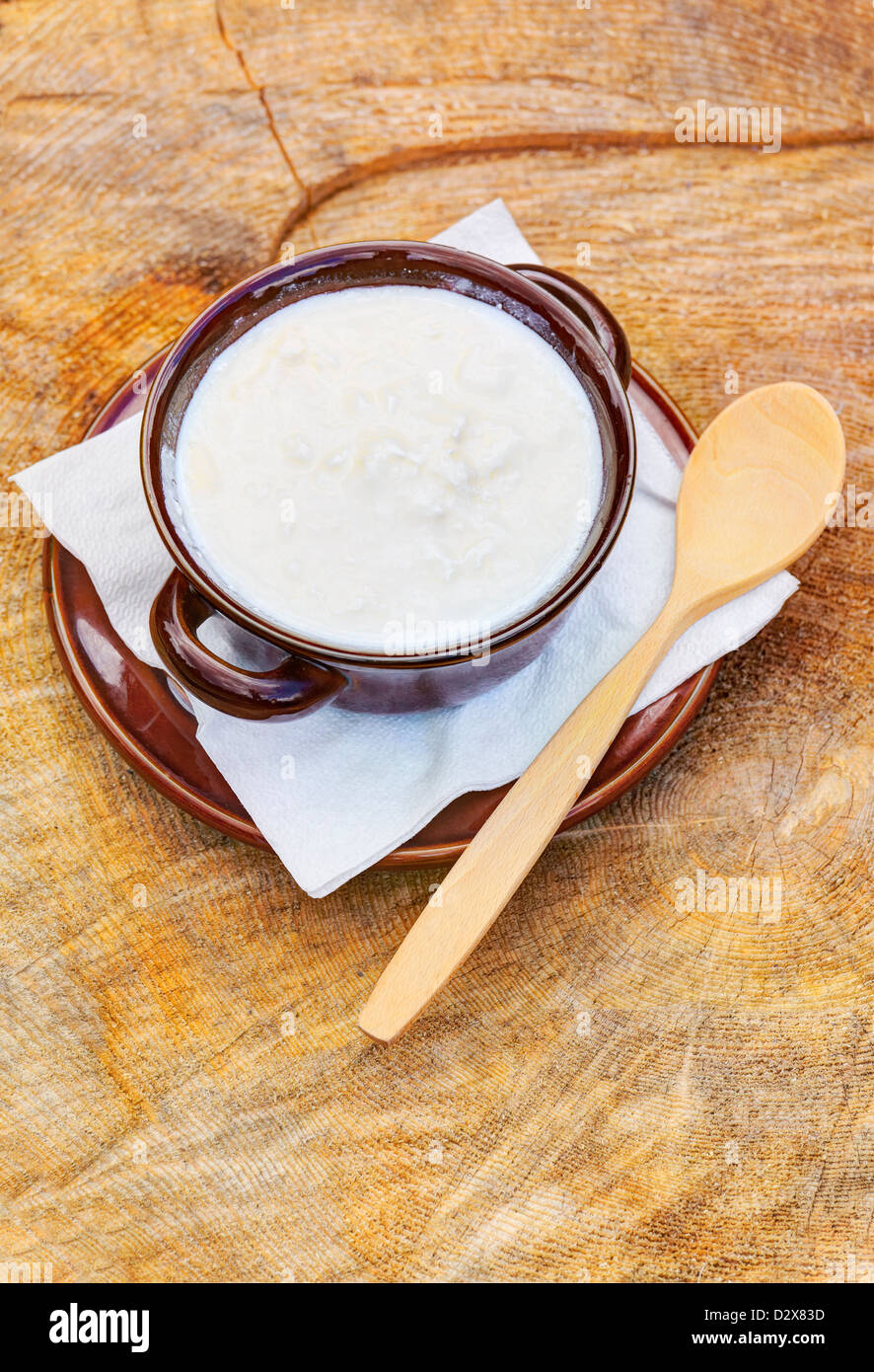 Bowl of organic goat yogurt with wooden spoon Stock Photo Alamy