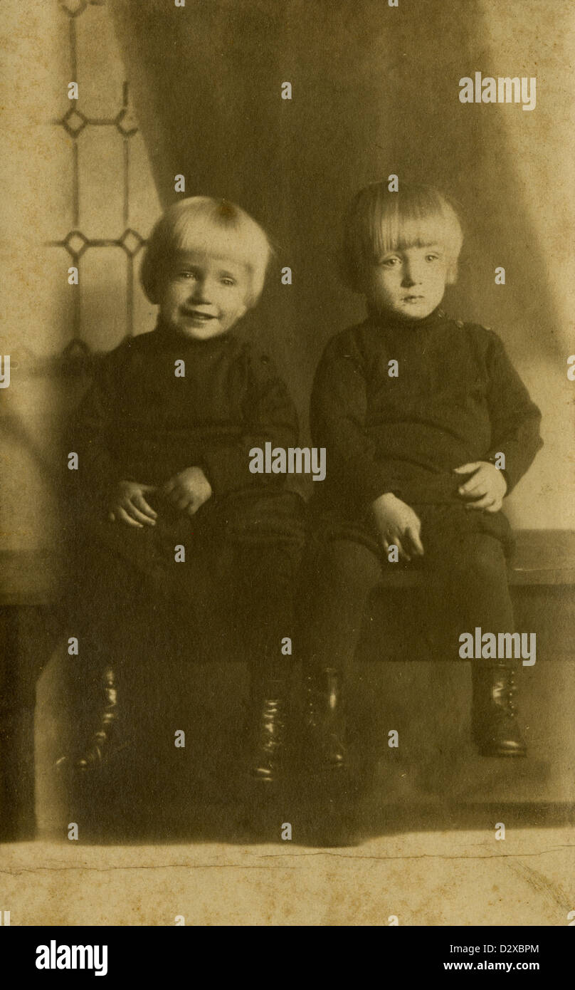Circa 1900 photograph, two little boys about 18-24 months old in Victorian dress. Perhaps twins. Stock Photo
