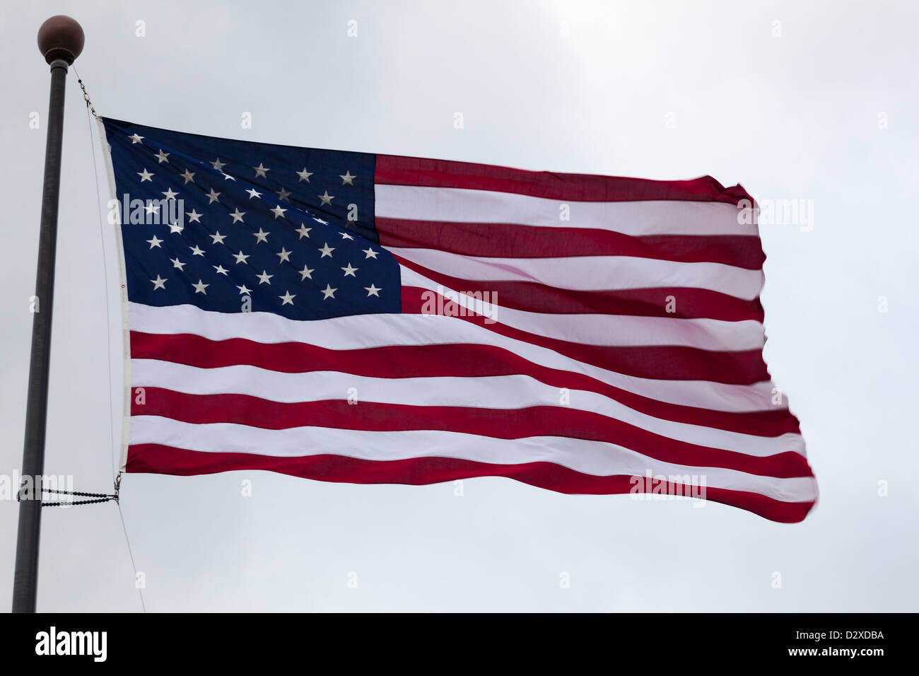 The flag of the United States of America on a flagpole flowing in the wind. Stock Photo