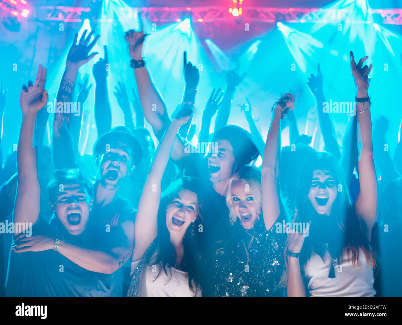 Portrait of enthusiastic crowd with arms raised at concert Stock Photo