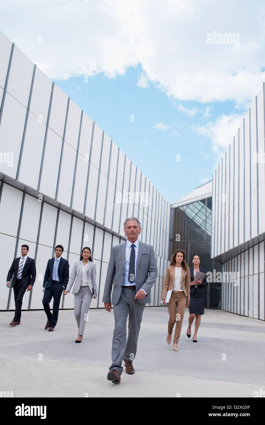 Confident business people walking outside building Stock Photo