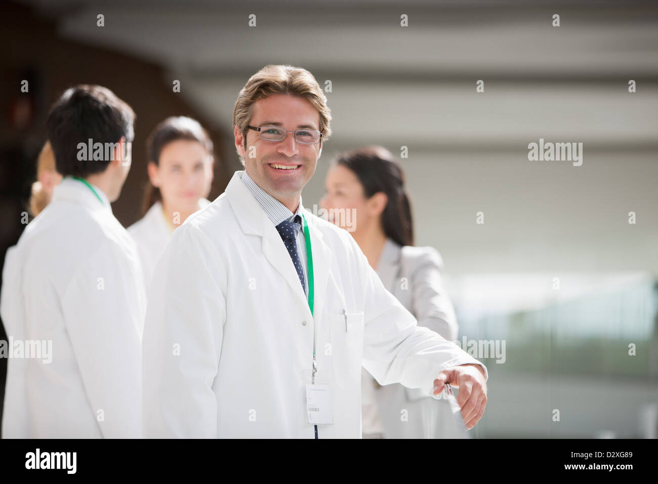 Portrait of smiling scientist with co-workers in background Stock Photo