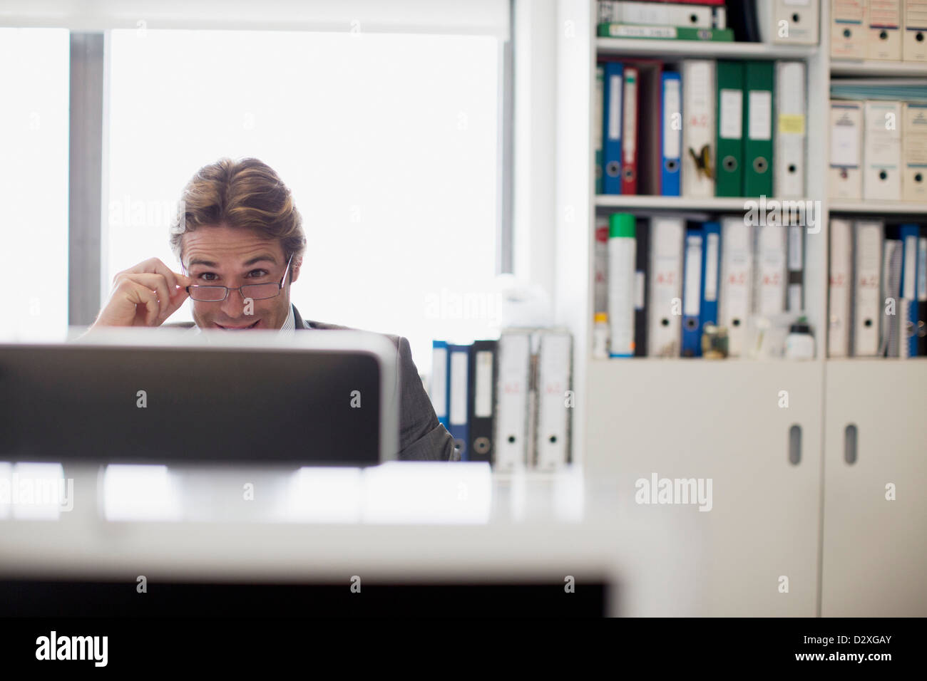 Businessman reading e-mail at computer in office Stock Photo