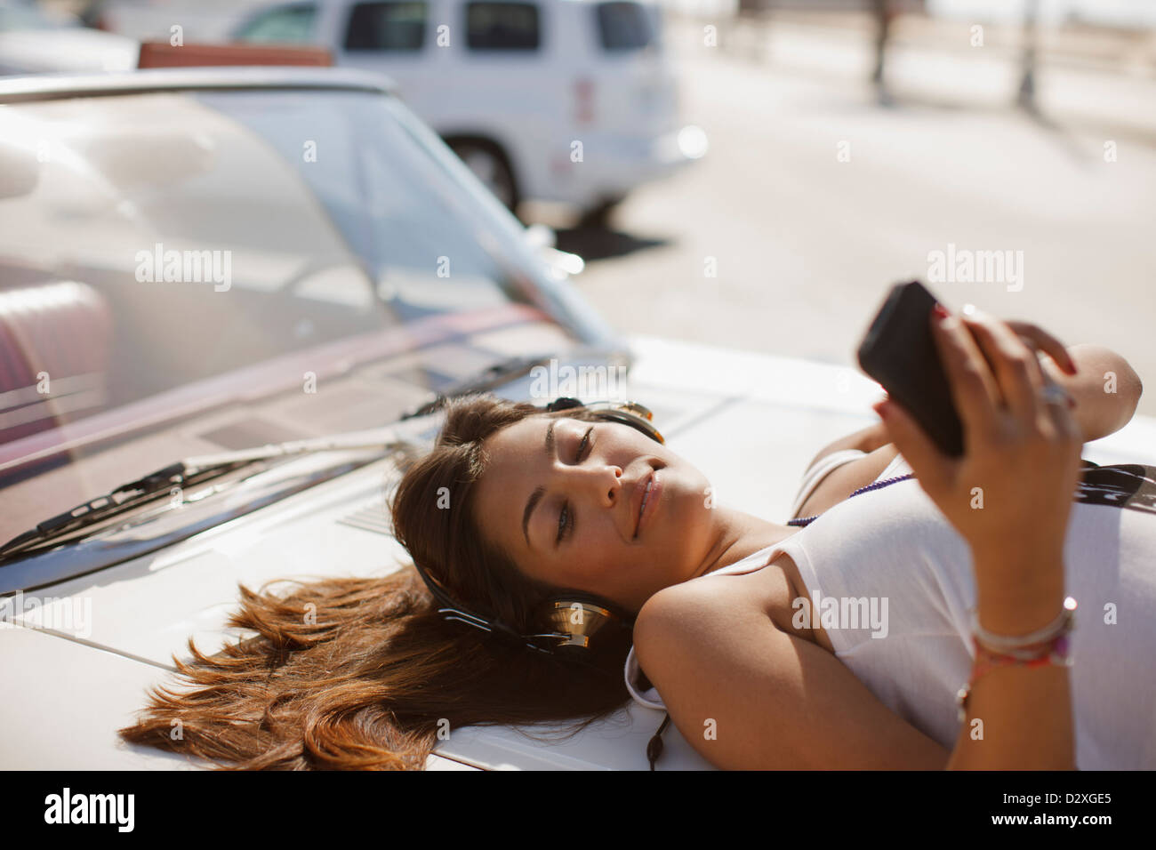 Woman listening to mp3 player on convertible Stock Photo