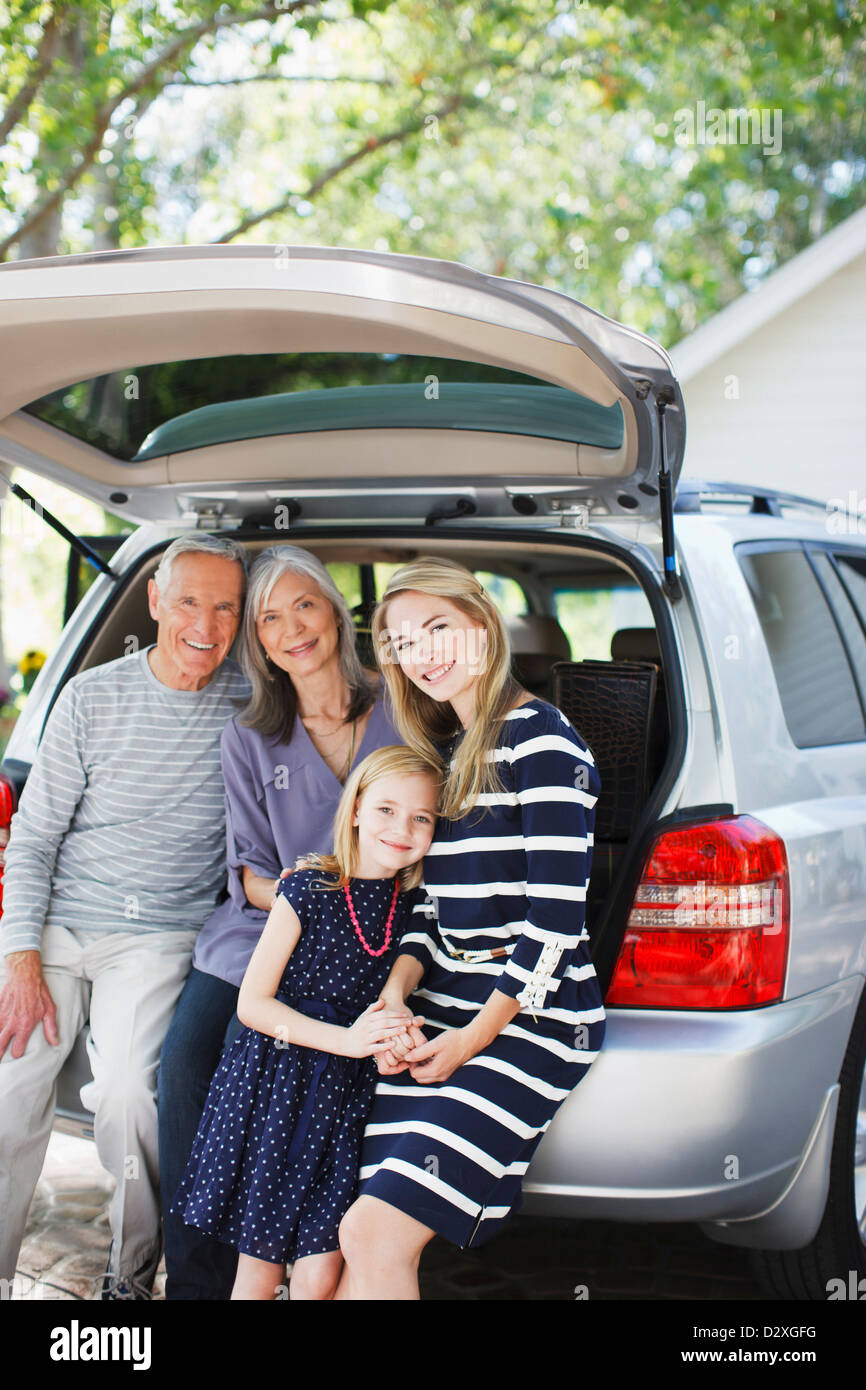 Family sitting in trunk of car Stock Photo