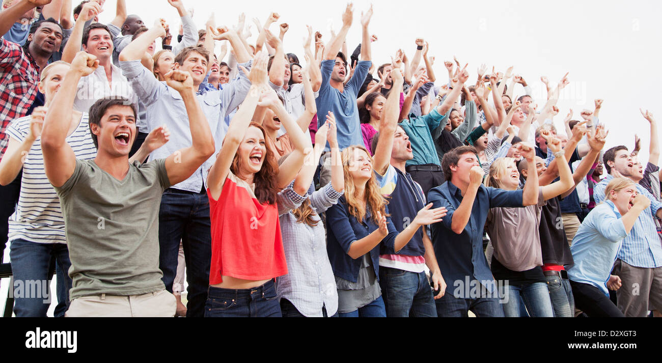 Cheering fans in crowd Stock Photo