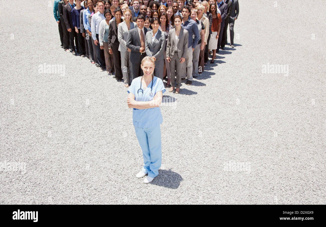 Portrait of confident nurse with business people in background Stock Photo