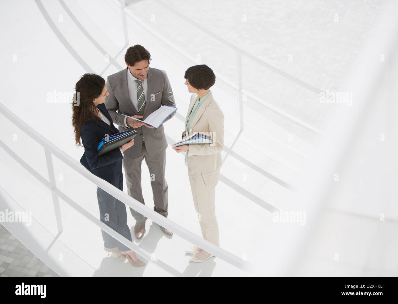 Business people reviewing paperwork on walkway Stock Photo - Alamy