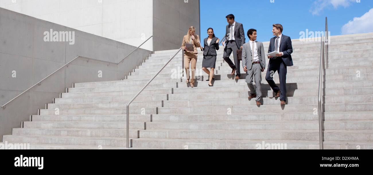Business people talking and descending urban stairs Stock Photo