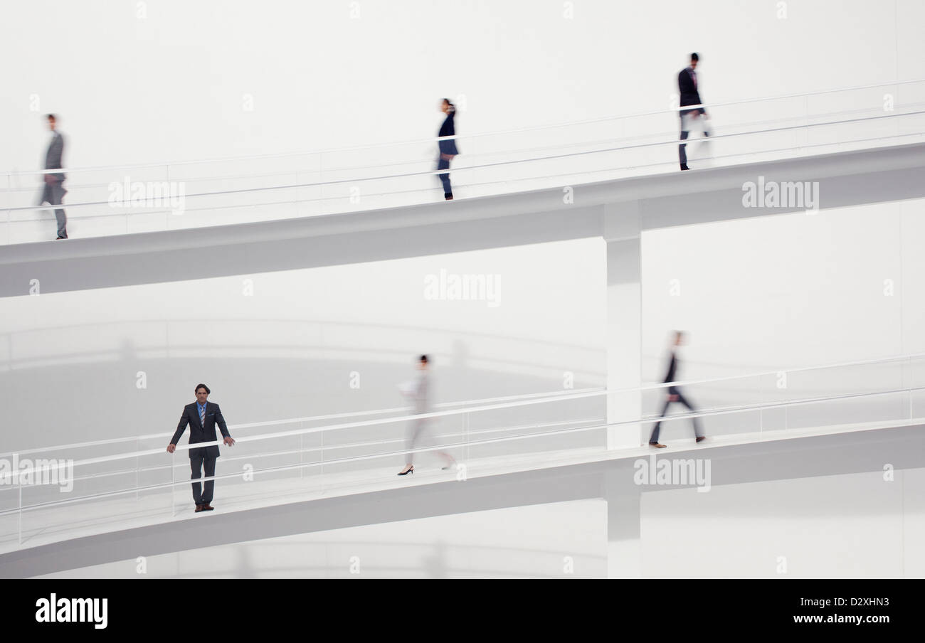 Blurred business people walking on elevated walkways Stock Photo - Alamy