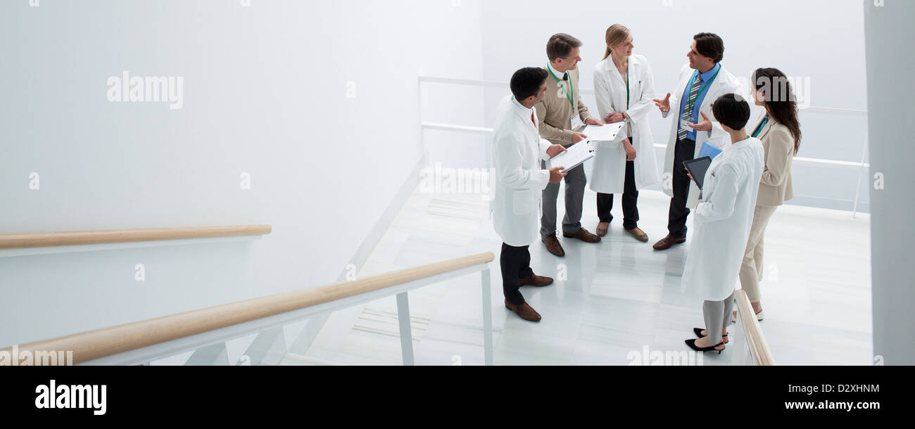 Business people and doctors meeting on landing of stairs Stock Photo