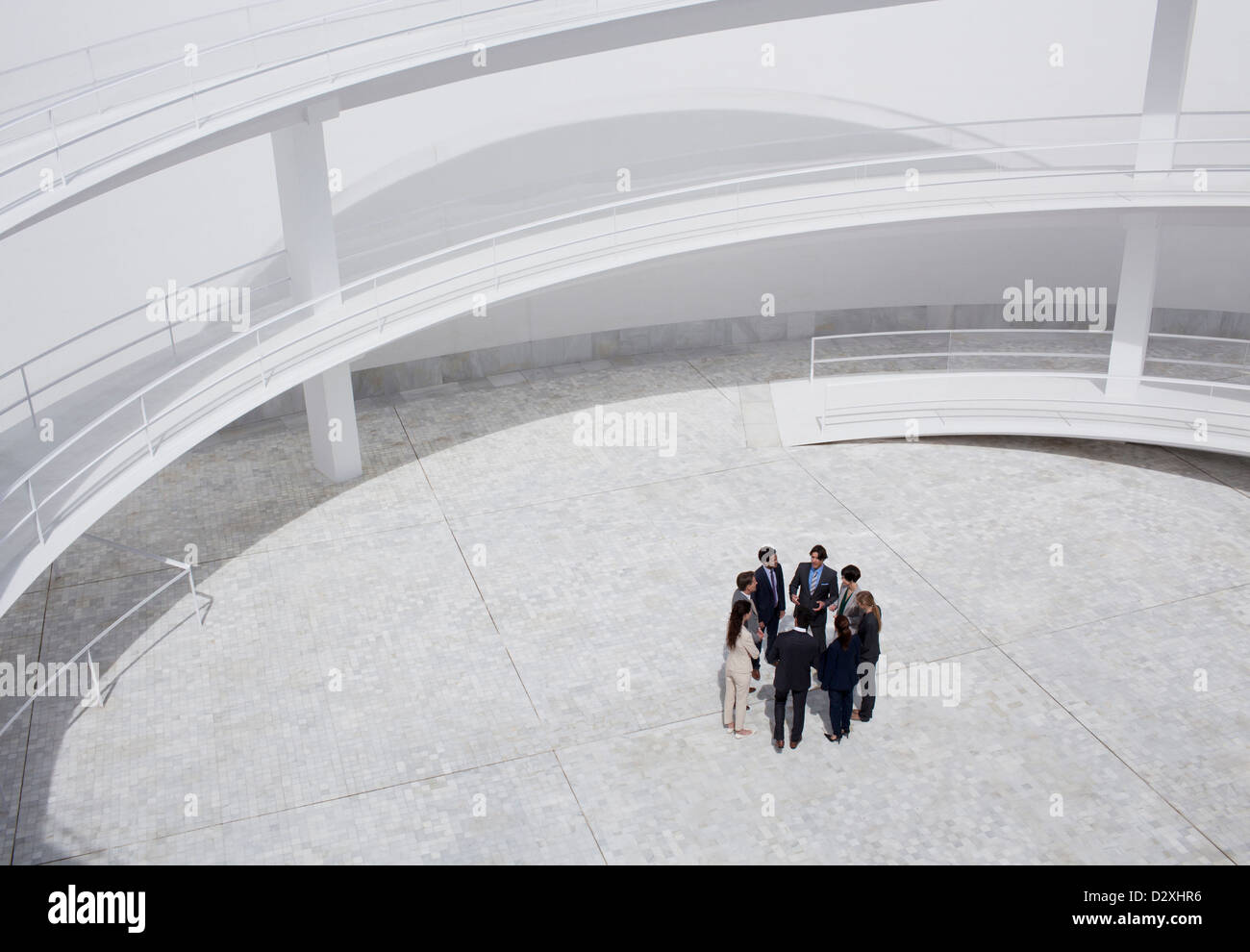 Business people standing in circle of modern courtyard Stock Photo