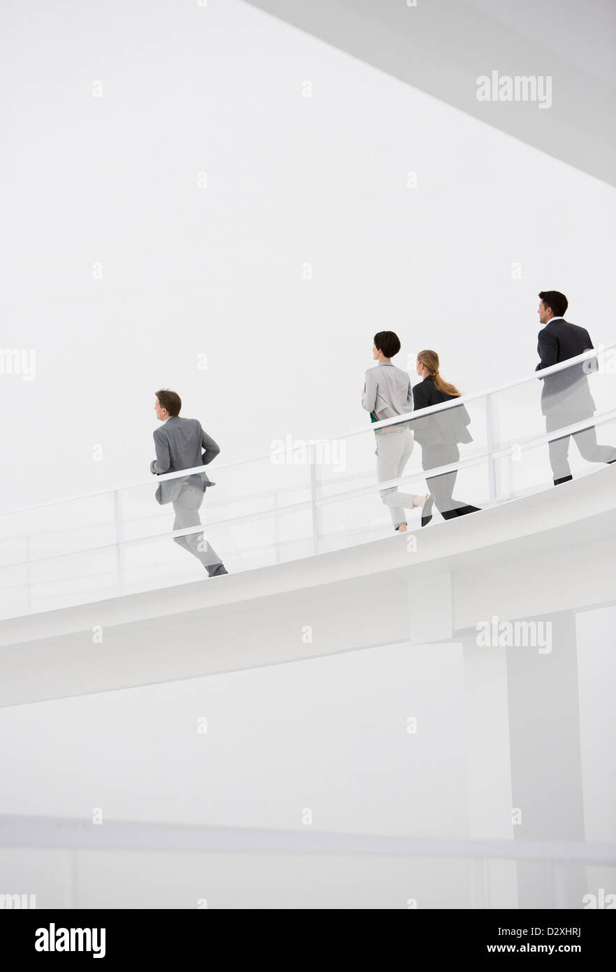 Business people running down elevated walkway Stock Photo