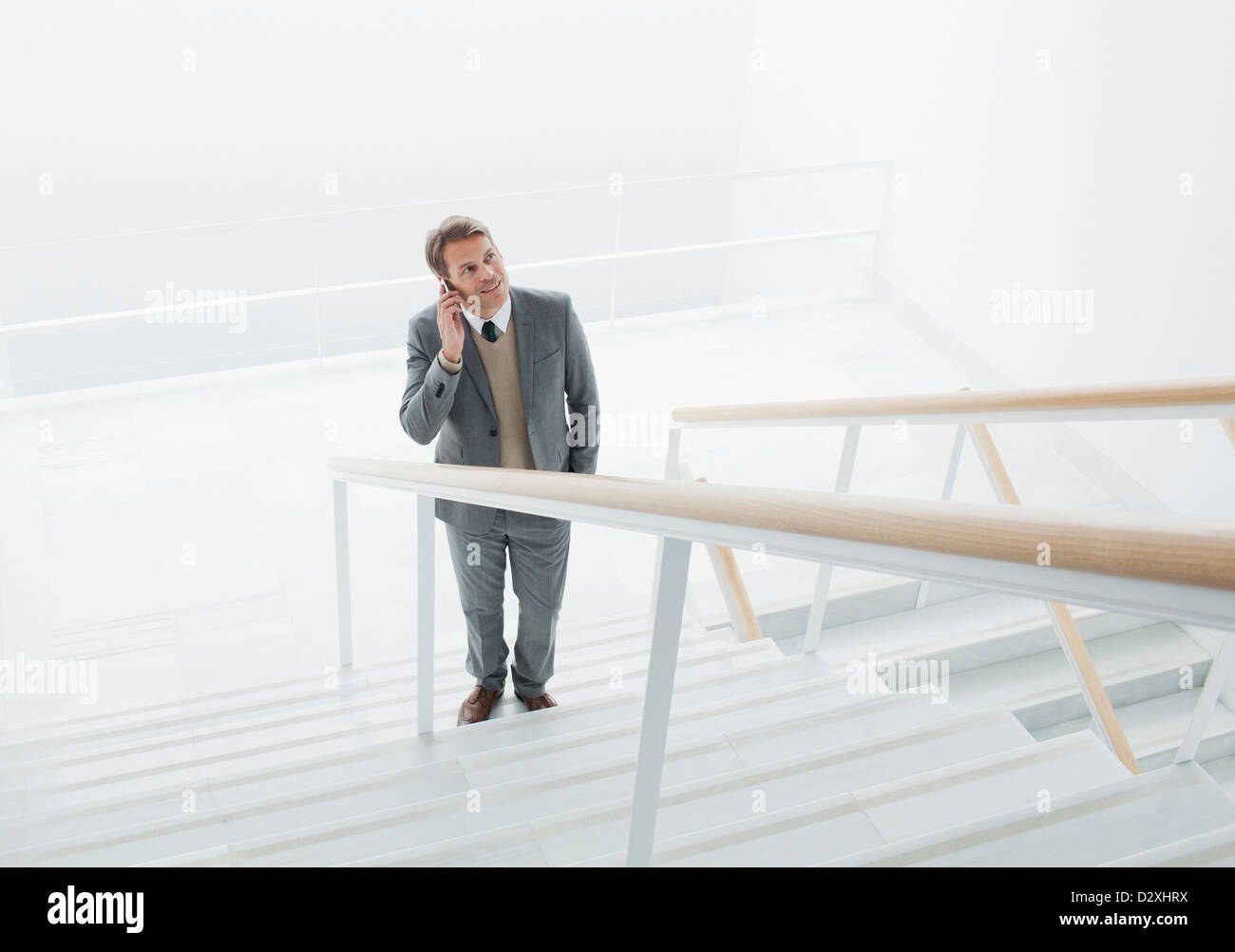 Businessman talking on cell phone at base of stairs Stock Photo